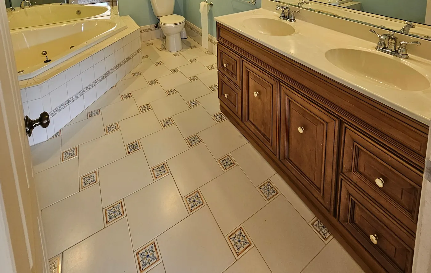 Double-sink bathroom vanity, tub edge and patterned tile floor